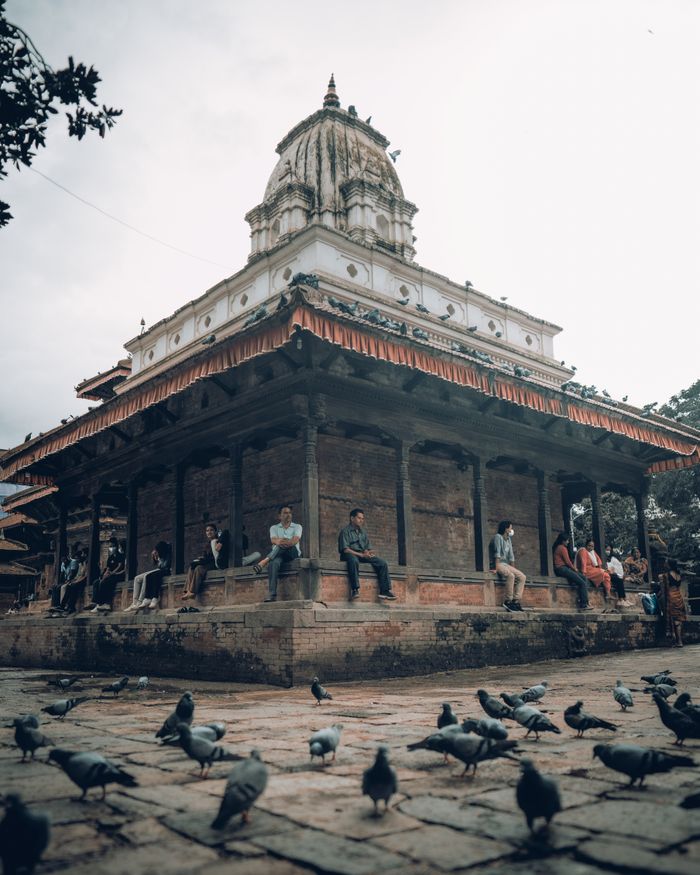 our-story Captivating scene of people and pigeons around a historic temple in Kathmandu, Nepal.